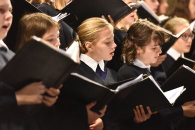 Mädchen singen und halten Notenbücher in den Händen